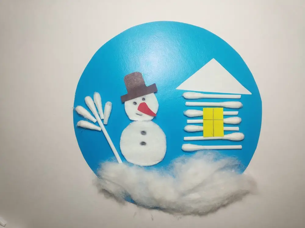 A cardboard snowman craft from absorbent cotton and ear sticks