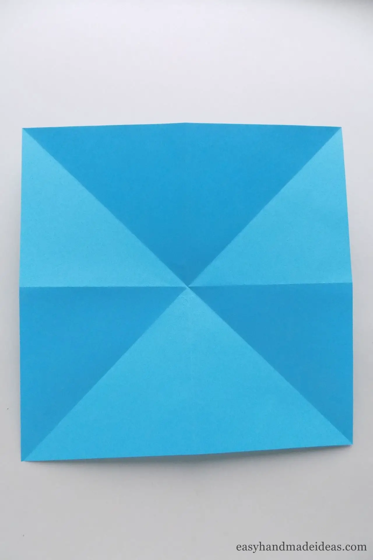 Make 2 diagonal folds and 2 cross folds
