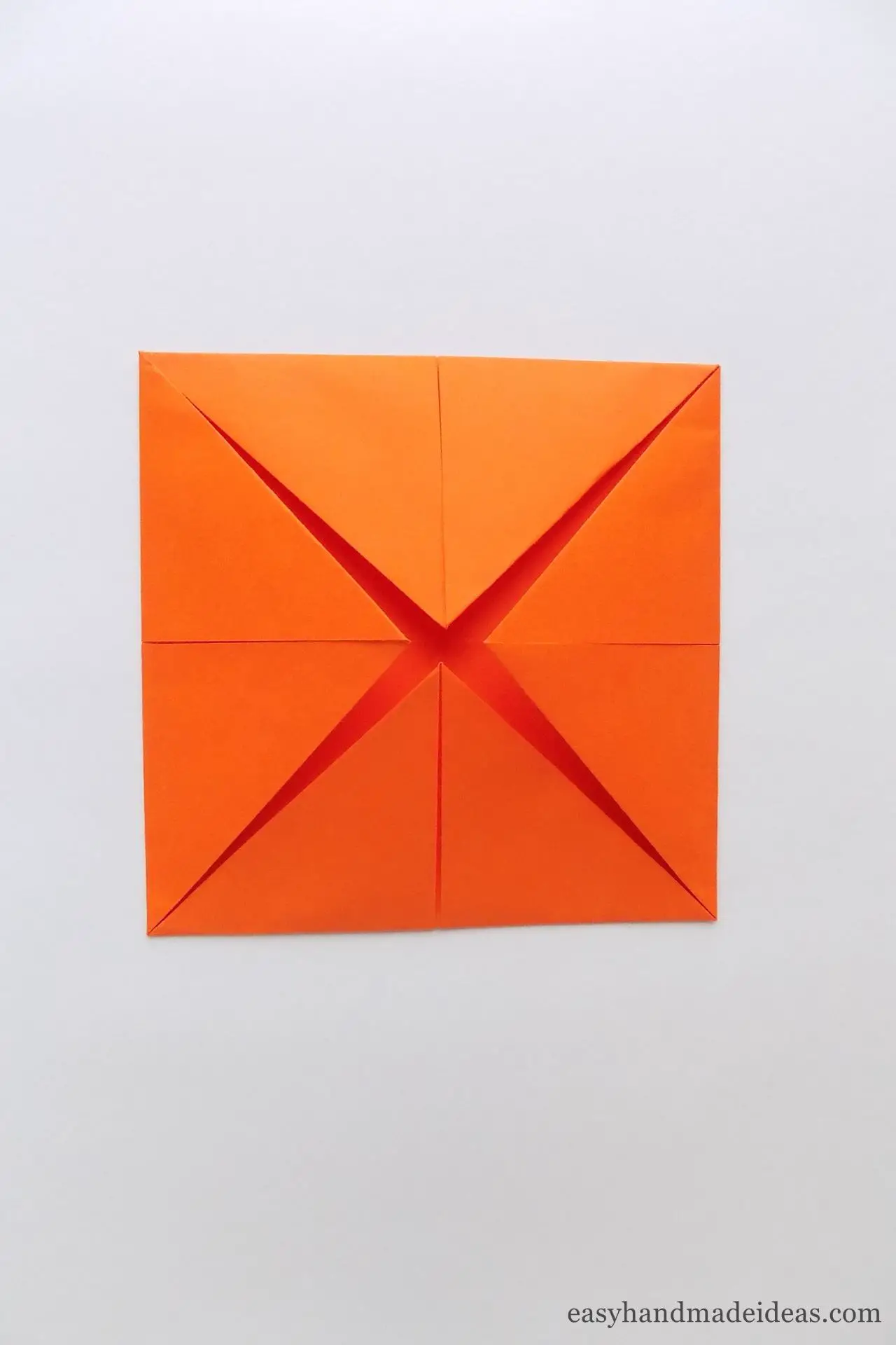 Fold the corners toward the center of the square